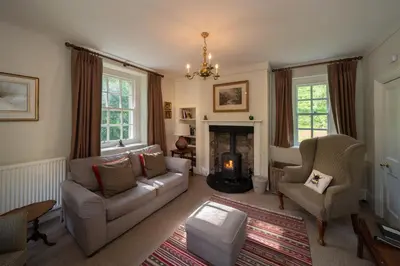 a living room with a couch and chairs and a fireplace at Gatehouse, Bridge of Balgie, Glenlyon in Bridge of Balgie