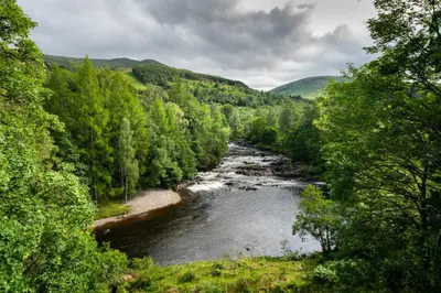 a river in the middle of a forest at Gatehouse, Bridge of Balgie, Glenlyon in Bridge of Balgie