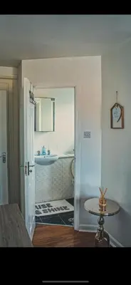a bathroom with a sink and a table in a room at Detached House with a private en suite room in Clydebank