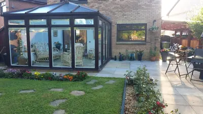 a greenhouse in a garden with a patio at Ceylon HomeStay in Knightswood