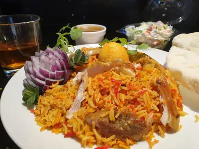 a plate of food with meat and rice on a table at Ceylon HomeStay in Knightswood