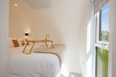 a bedroom with a bed with a table on it at The Stag, Luxury pod with hot tub, Croft4glamping in Oban