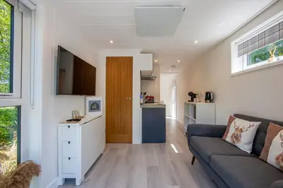 a living room with a couch and a kitchen at The Stag, Luxury pod with hot tub, Croft4glamping in Oban