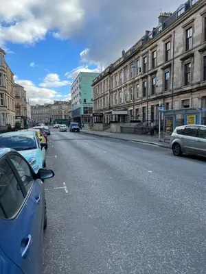 a street with cars parked on the side of the road at Sauchiehall Street West End Apartment in Glasgow