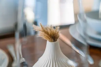 a white vase with a plant in it on a table at Quirky, Family Home in Glasgow in Cardonald