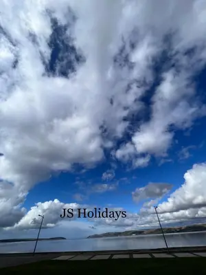 a sign that reads us holidays under a cloudy sky at JS Holidays The Westmorland Lagganhouse in Ballantrae