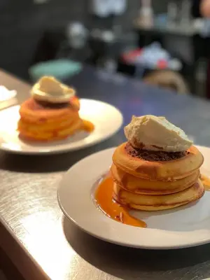 two plates of pancakes with ice cream on a counter at Rooms Above Sugar Boat in Helensburgh