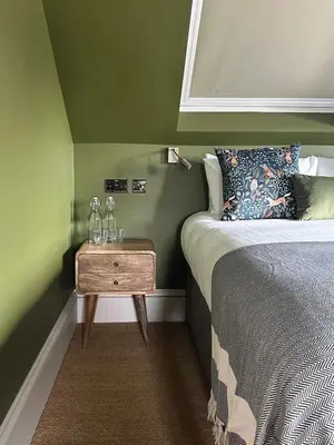 a bedroom with a bed and a table with glasses on it at Rooms Above Sugar Boat in Helensburgh