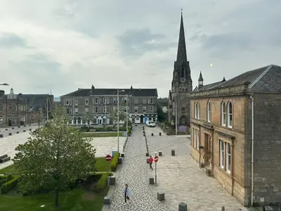 a group of people walking down a street in a city at Rooms Above Sugar Boat in Helensburgh