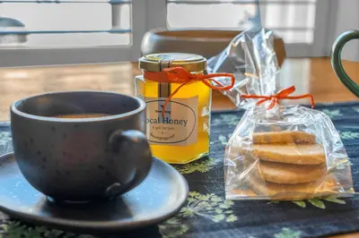 a cup of coffee and a bag of bread on a table at Beeswing, a Victorian Gem in Biggar in Biggar