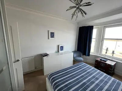 a bedroom with a blue and white bed and a window at Fantastic 3 bedroom holiday home in Millport