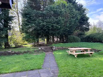 a wooden picnic table in the grass with a path at Cunninghame 2 in Beith
