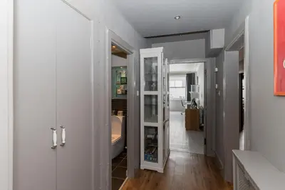 a hallway with white cabinets and a bathroom at Beautiful & Bright 2BD Flat - Haymarket in Edinburgh