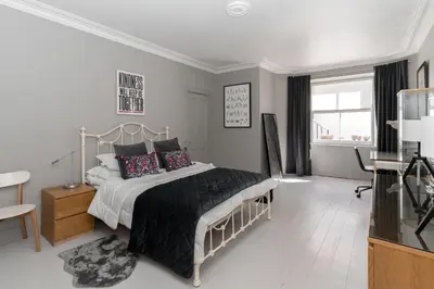 a bedroom with a bed and a desk and a window at Beautiful & Bright 2BD Flat - Haymarket in Edinburgh