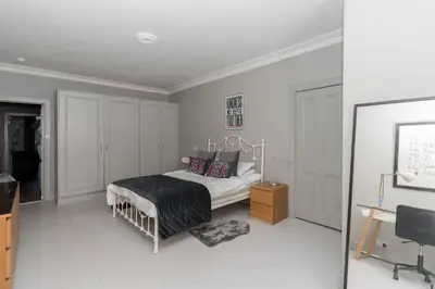 a white bedroom with a bed and a desk at Beautiful & Bright 2BD Flat - Haymarket in Edinburgh
