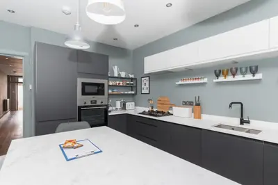 a kitchen with a white counter top and a sink at Beautiful & Bright 2BD Flat - Haymarket in Edinburgh