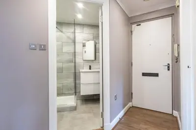 a bathroom with a white door and a mirror at ** Modern Merchant City 1 BED Apartment with Free Parking ** in Glasgow