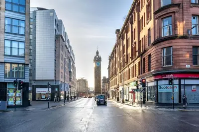 a city street with a clock tower in the distance at ** Modern Merchant City 1 BED Apartment with Free Parking ** in Glasgow