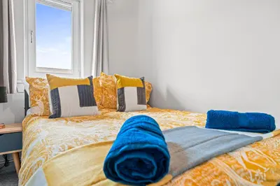 a bed with a blue blanket on top of it at I'm Your Host - Bridgeton House in Glasgow