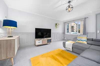 a living room with a couch and a tv at I'm Your Host - Bridgeton House in Glasgow