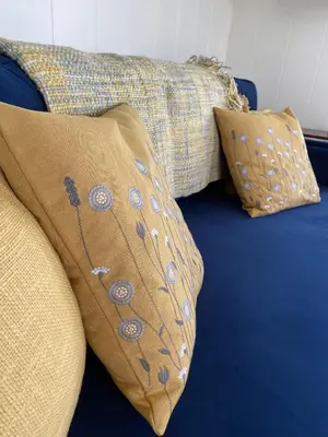 a blue couch with two pillows on it at Patie's Hill in Penicuik
