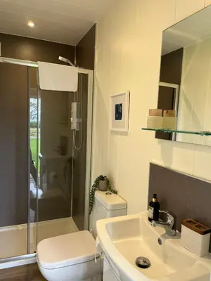 a bathroom with a sink and a toilet and a shower at Patie's Hill in Penicuik
