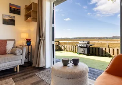 a living room with a view of the field from a patio door at East Kip - Dog Friendly in Penicuik
