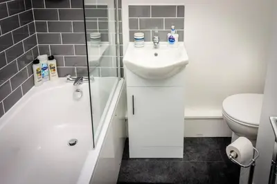 a white bathroom with a sink and a toilet at Modern bright studio apartment in south Glasgow in Glasgow