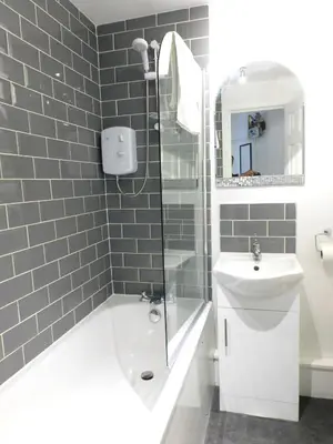 a bathroom with a shower and a toilet and a sink at Modern bright studio apartment in south Glasgow in Glasgow
