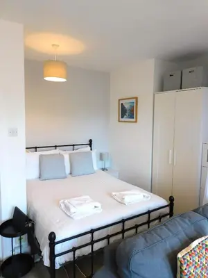 a bedroom with a bed and a blue couch at Modern bright studio apartment in south Glasgow in Glasgow