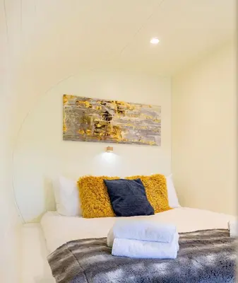 a bedroom with a bed with a painting on the wall at South Black Hill in Penicuik