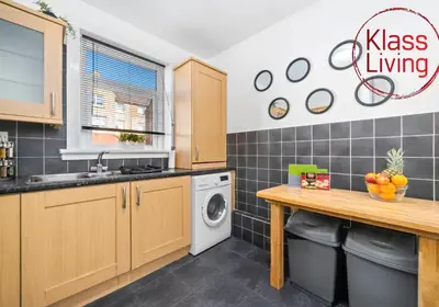 a kitchen with a sink and a washing machine at Coats Street Apartment by Klass Living Coatbridge in Coatbridge