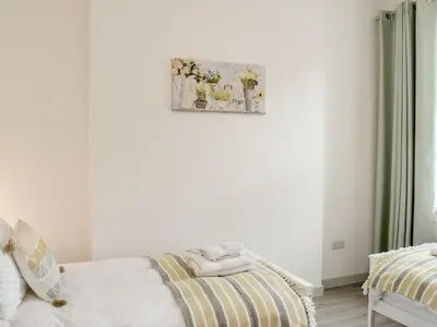a bedroom with a bed and a picture on the wall at Miners Cottage in Girvan