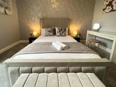 a bedroom with a large bed with two towels on it at Premium 2BR Flat in the City Centre in Glasgow