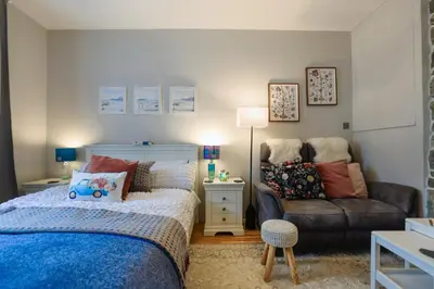 a bedroom with a bed and a couch at Small Cosy Studio Flat Near the Sea, Central Oban in Oban