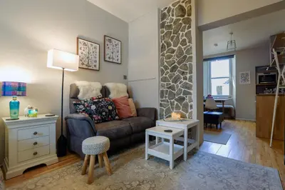 a living room with a couch and a table at Small Cosy Studio Flat Near the Sea, Central Oban in Oban