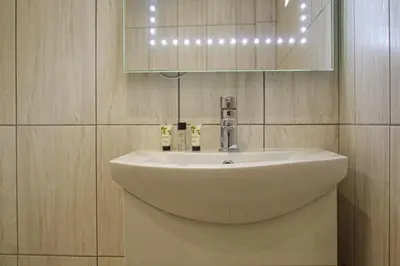 a bathroom with a white sink and a mirror at Lavish 2 bed sleeps 5 near Lanark in Carstairs