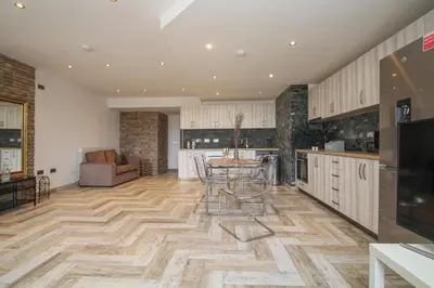 a kitchen with a table and chairs on a wooden floor at Lavish 2 bed sleeps 5 near Lanark in Carstairs