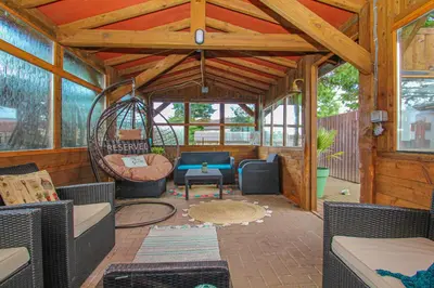 a screened in porch with a couch and a swing at Lavish 2 bed sleeps 5 near Lanark in Carstairs
