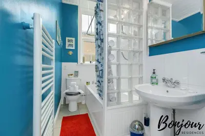 a blue and white bathroom with a sink and a toilet at Anvers Suite in Edinburgh