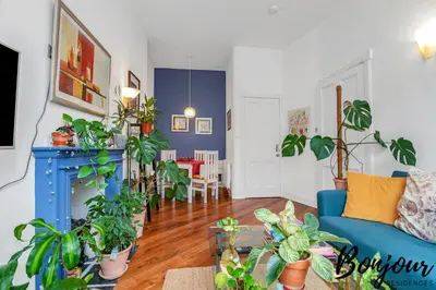 a living room with a blue couch and lots of plants at Anvers Suite in Edinburgh