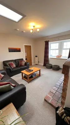 a living room with a couch and a table at Popsal in Kirkcowan