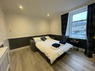 a bedroom with a bed with pillows and a window at Strathisla Garden Apartment, Oban in Oban