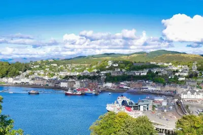 a city with boats docked in a body of water at Strathisla Garden Apartment, Oban in Oban