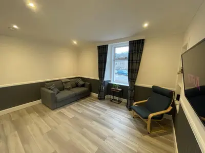 a living room with a couch and a tv at Strathisla Garden Apartment, Oban in Oban