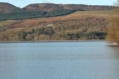 a large body of water with mountains in the background at The Mews - a cottage with a spectacular lake view in Port of Menteith
