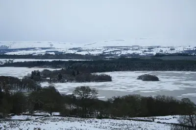 a view of a river with snow on the ground at The Stable - cottage with a spectacular lake view in Port of Menteith