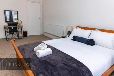 a bedroom with a large bed with towels on it at Complex Suite in Glasgow