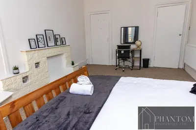a bedroom with a bed with a white towel on it at Complex Suite in Glasgow