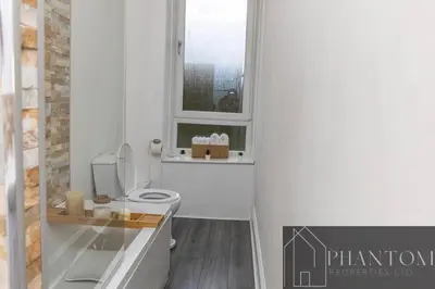 a bathroom with a toilet and a window at Complex Suite in Glasgow